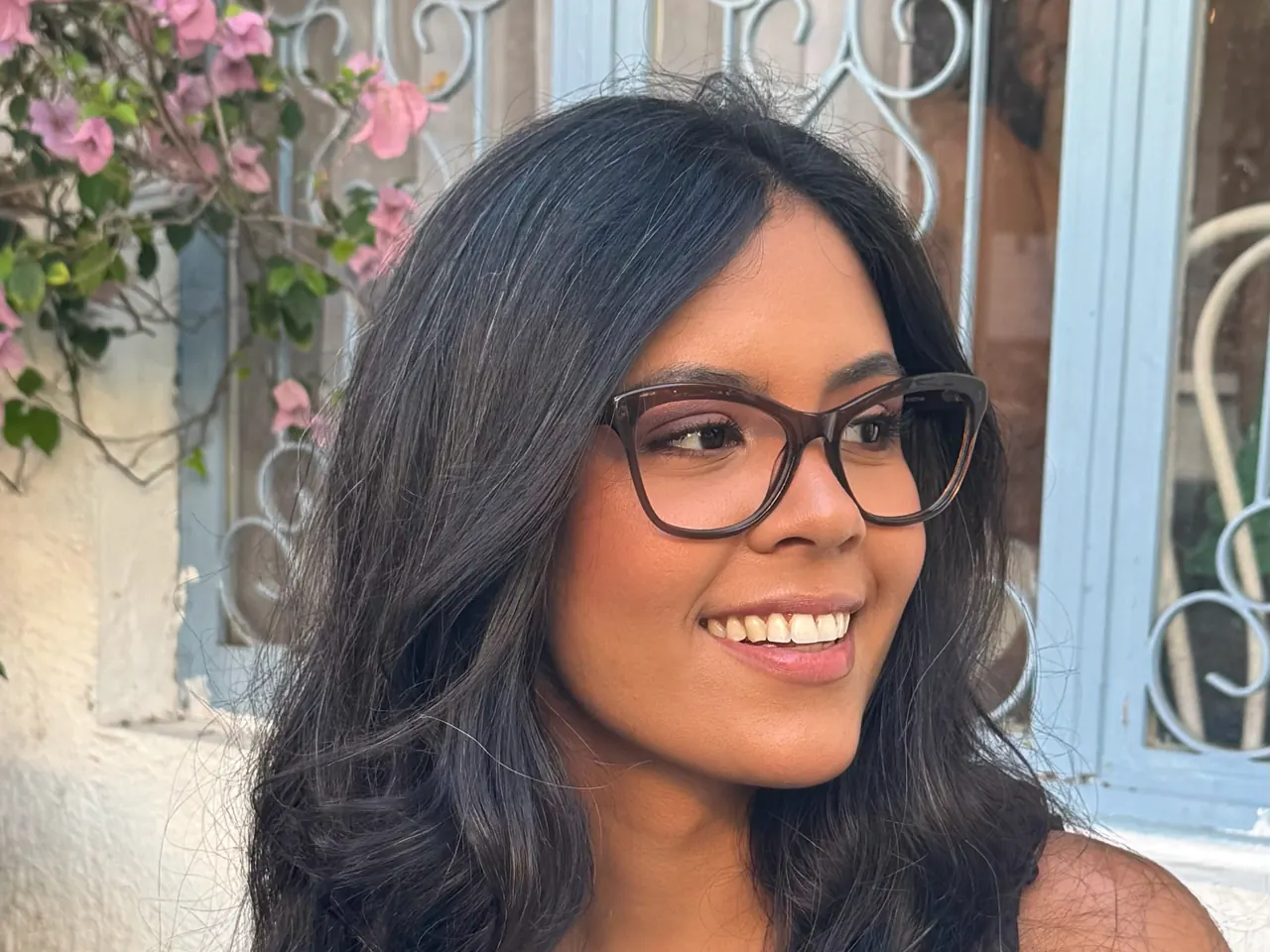 Mulher sorrindo com óculos de grau de armação escura