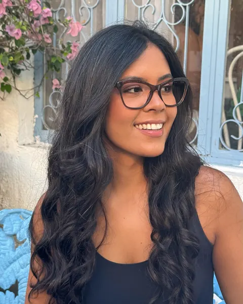 Mulher sorrindo com óculos de grau de armação escura