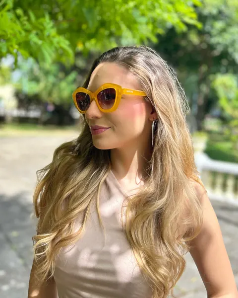 Mulher usando óculos de sol de armação amarela